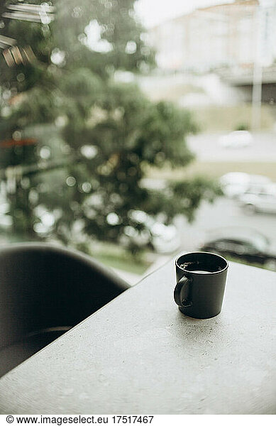 Single coffee cup on table with an urban background