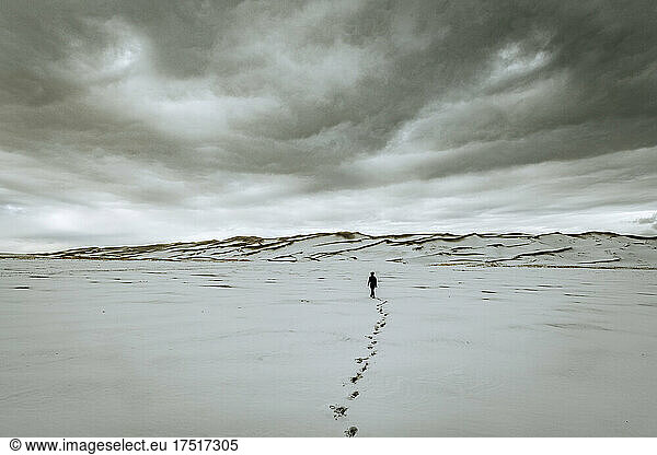 single person and footsteps clouds  sand dunes national park Colorado