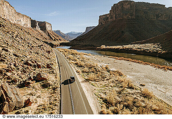 single truck drives through beautiful red canyon Moab Utah