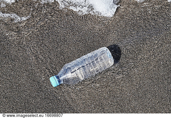 Single-use plastic bottle floating in the sea