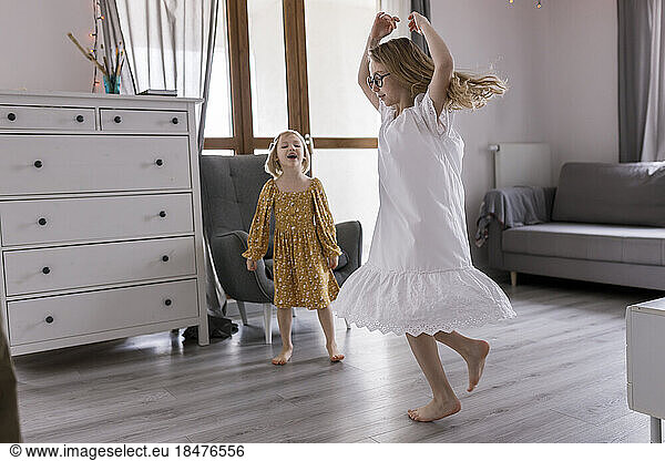 Sisters enjoying dance in living room at home