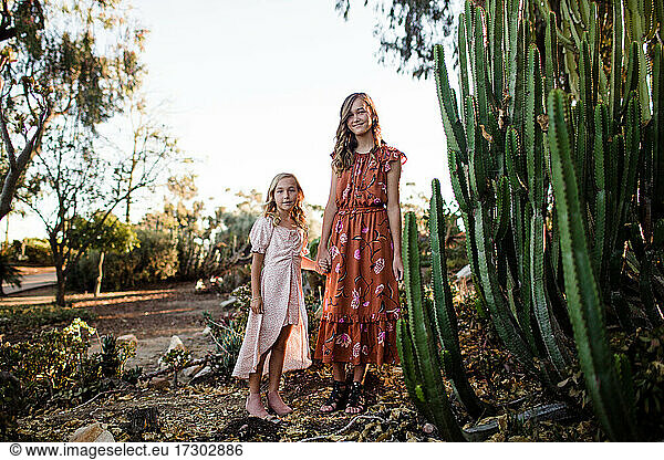 Sisters Holding Hands While Standing in Desert Garden in San Diego