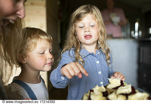 Sisters looking at sweet pastries on plate