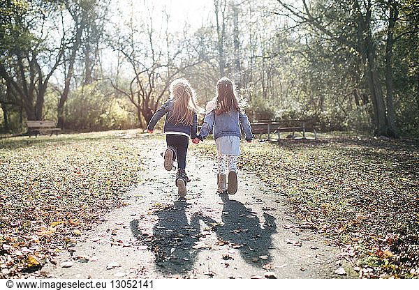 Sisters running in forest