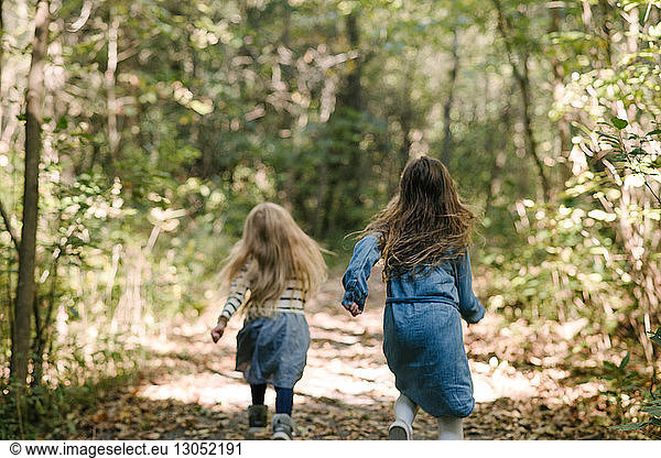 Sisters running in forest