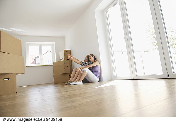 sitzend Ehepaar Holzboden Eigentumswohnung neues Zuhause