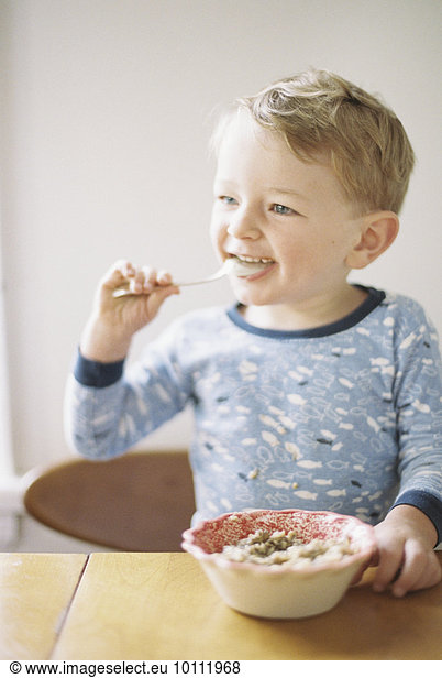 sitzend Junge - Person jung Schüssel Schüsseln Schale Schalen Schälchen essen essend isst Tisch Frühstück