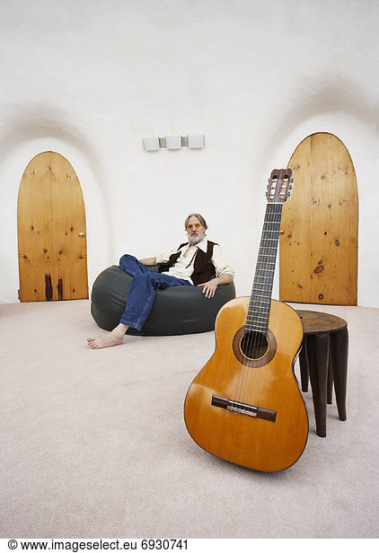 sitzend Mann Stuhl Tasche Gitarre Fokus auf den Vordergrund Fokus auf dem Vordergrund Bohne