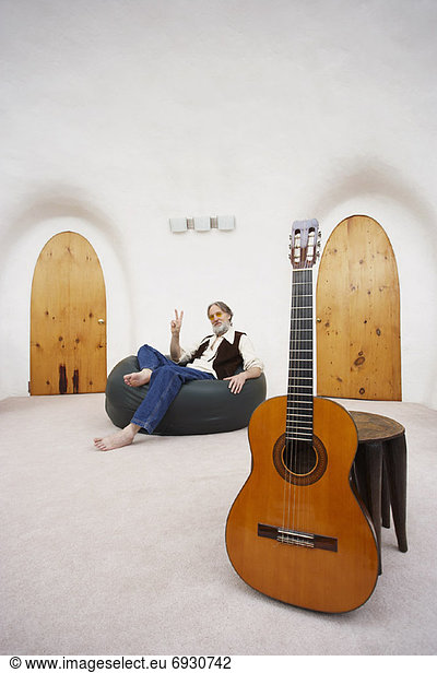 sitzend  Mann  Stuhl  Tasche  Gitarre  Fokus auf den Vordergrund  Fokus auf dem Vordergrund  Bohne