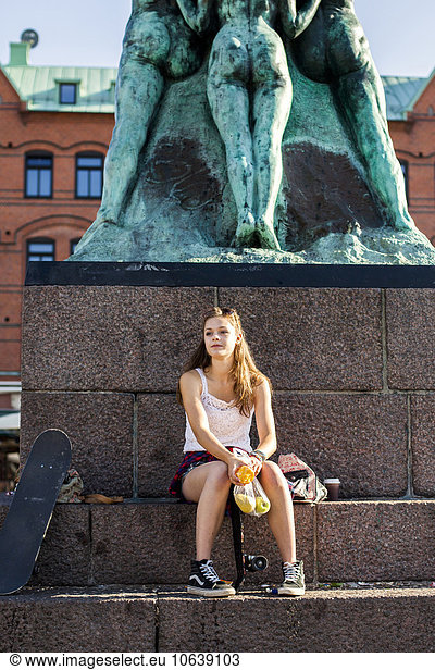 sitzend Wand Statue zurückhalten Mädchen