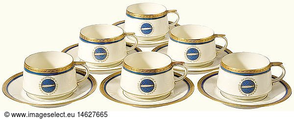 Six mocha cups with saucers  from the German Zeppelin Shipping Line. Etched gold decorative rim set off with blue  and with the blue-gold emblem of the DZR (Deutsche Zeppelin Reederei) on both cups and saucers. Manufacturer's mark on the bottoms  'Heinrich-Elfenbein-Porzellan Bavaria  Selb' and 'Eigentum der Zeppelin-Reederei' (Property of the Zeppelin Shipping Line). Height of the cups 40 mm. Diameter of the saucers 11 cm. historic  historical  20th century  transport  transportation  object  objects  stills  dishes  dish  plate  plates  porcelain  chinaware