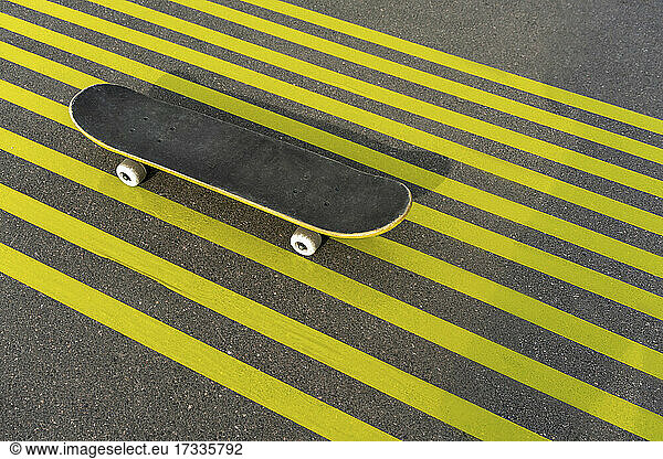 Skateboard on striped yellow road marking