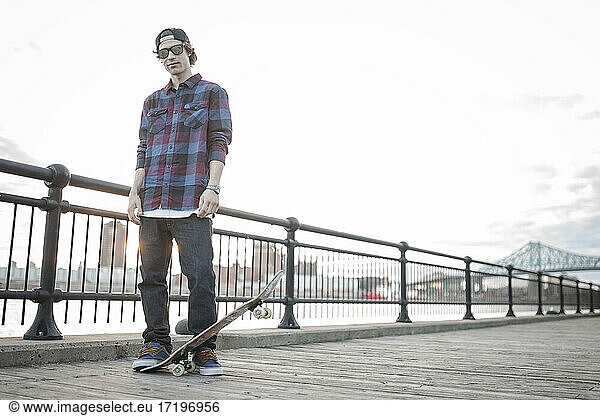 Skateboarder auf Kai mit Stadtbild dahinter