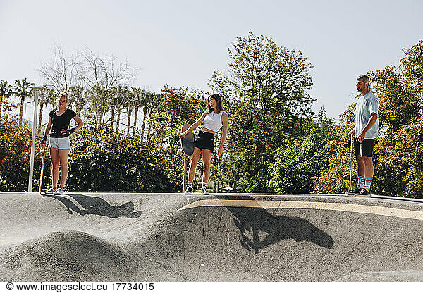 Skateboarders holding skateboards on sports ramp