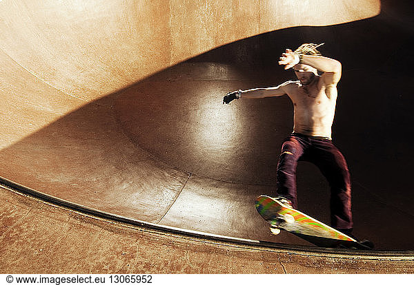 Skateboardfahren ohne Hemd auf der Sportrampe