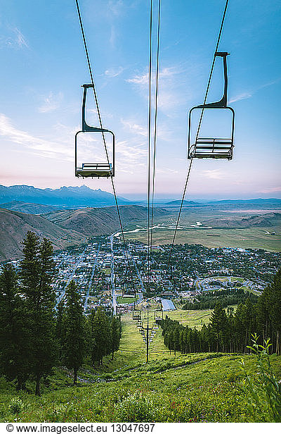 Ski lift over mountain with city in background