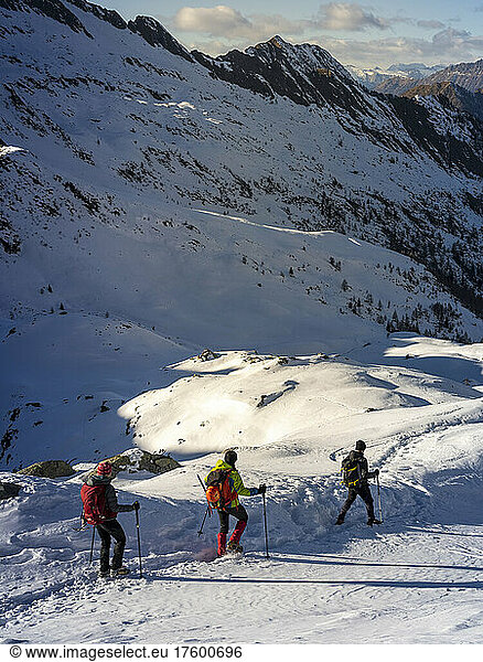 Ski mountaineerers following each other walking on snowy trail at Orobic Alps in Valtellina  Italy