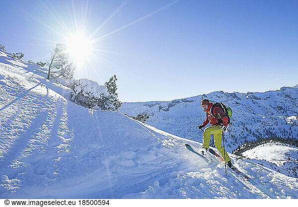 Skier climbing up on snow covered mountain