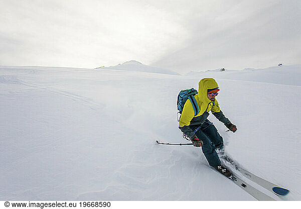 Skier enjoying fresh tracks on a remote mountain in Canada