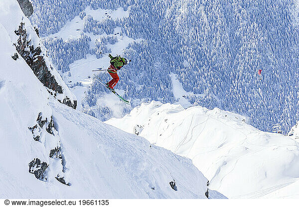 Skier jumping off a cliff in the powder.