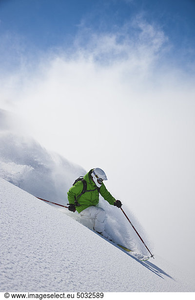 Skier skiing down through slope