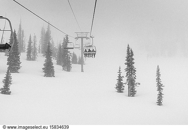 Skiers on chairlift in blizzard