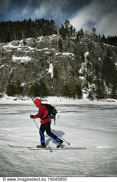 Skiing on Moosehead Lake below the lower cliffs of Mount Kineo  Maine.