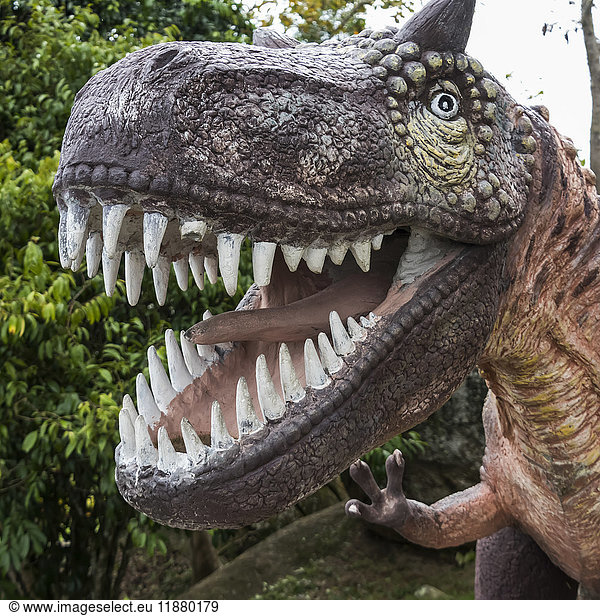 Skulptur eines Dinosauriers mit weit geöffnetem Maul  das seine Zähne zeigt; Ko Samui  Chang Wat Surat Thani  Thailand'.