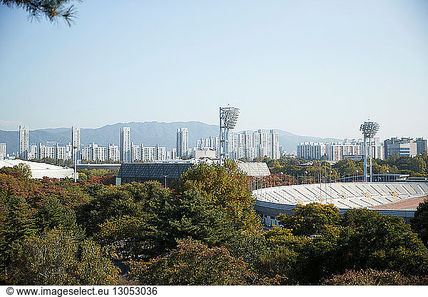 Skyline in daytime  national park and sports stadium in foreground  Seoul  South Korea