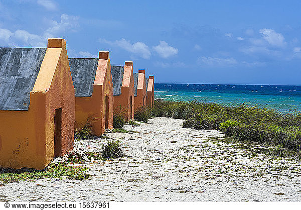 Slave huts at beach against blue sky during sunny day  Bonaire  ABC Islands  Caribbean Netherlands