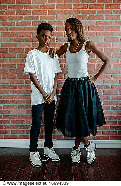 Slender black mom & preteen son in white t-shirts &matching sneakers