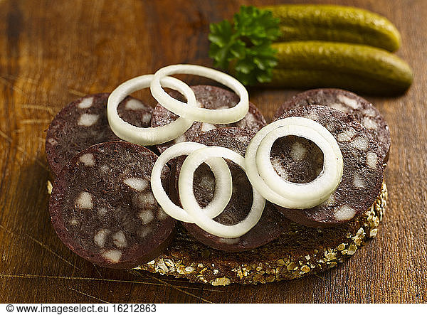 Slice of bread with blood sausage and onion rings  close-up