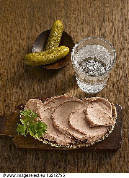 Slice of bread with liverwurst and glass of water