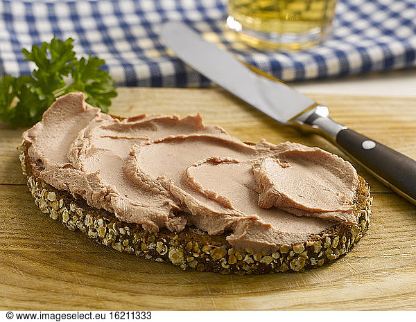 Slice of bread with liverwurst and knife  close-up