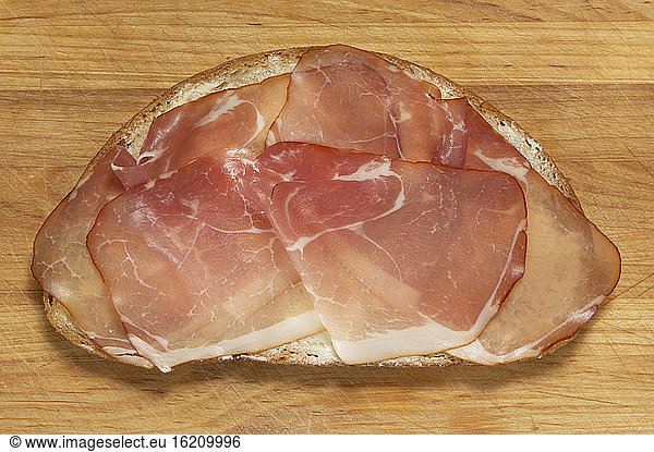 Slice of bread with raw ham  elevated view