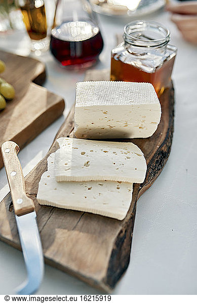 Sliced soft cheese on piece of wood