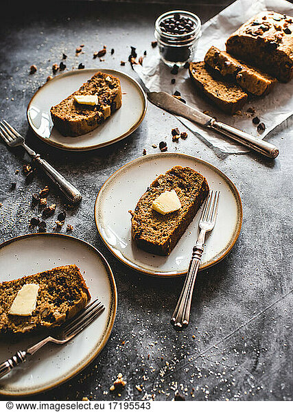 Slices of freshly baked banana bread on plates on a gray background.