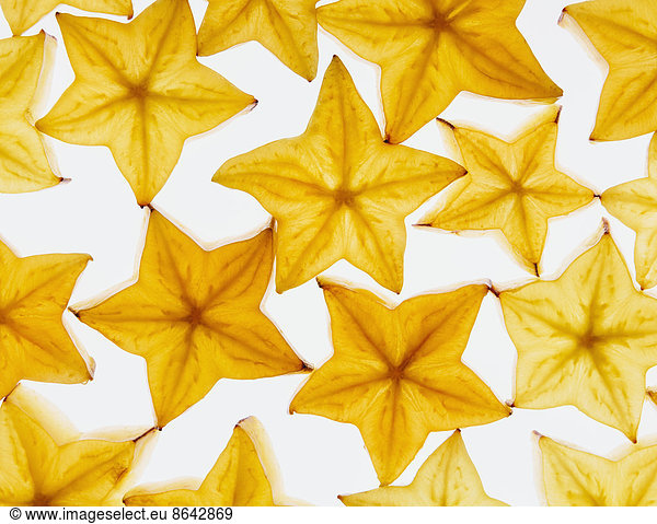 Slices of organic starfruit on a white background