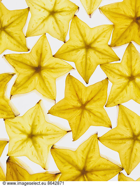 Slices of organic starfruit on white background