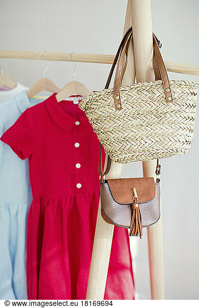 Sling bag and handbag on clothes rack in store