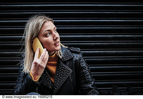 Slovak young woman talking with cellphone in city.