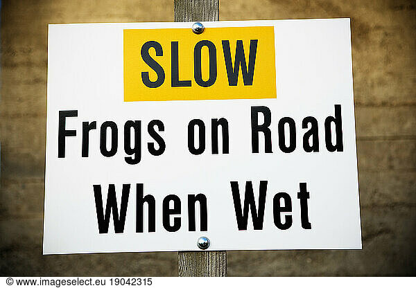 Slow frogs on road when wet sign.