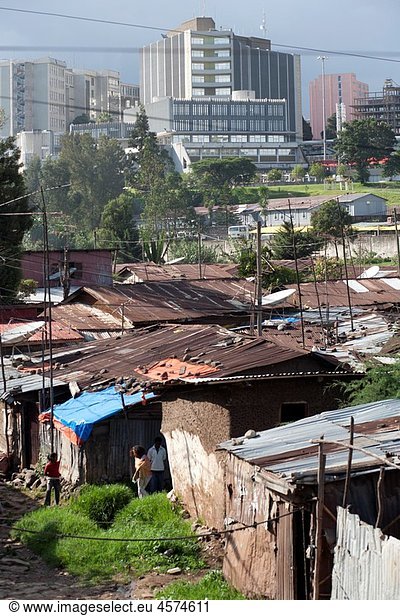 Slums in downtown Addis Ababa with government buildings in the background dark sky Ethiopia East Africa.