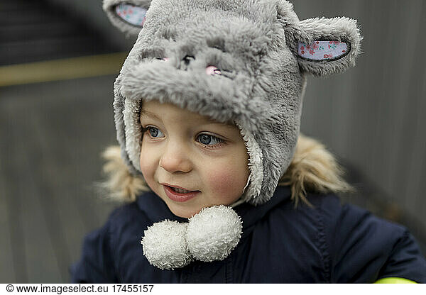 Small Boy in a grey furry hat smiling