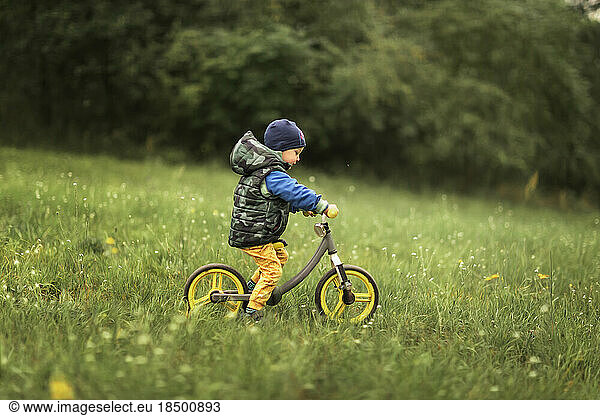 Small boy riding push bike down the hill