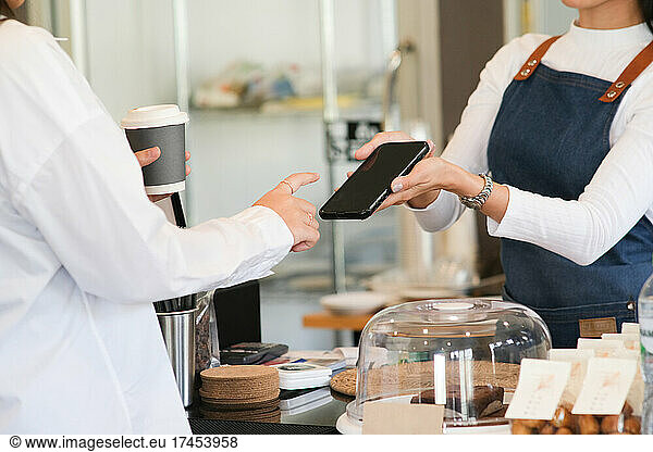 Small business owner and contactless or wireless payment concept