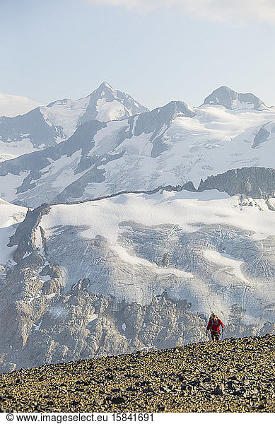 Small hiker juxtaposed against large glaciated mountains