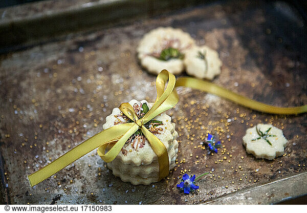 Small Stack of Shortbread Cookies with Bow Tie  Edible Flowers and Gold Sugar  High Angle View