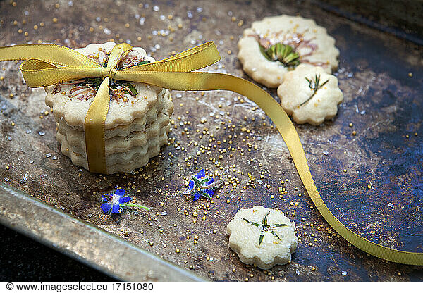 Small Stack of Shortbread Cookies with Bow Tie  Edible Flowers and Gold Sugar  High Angle View