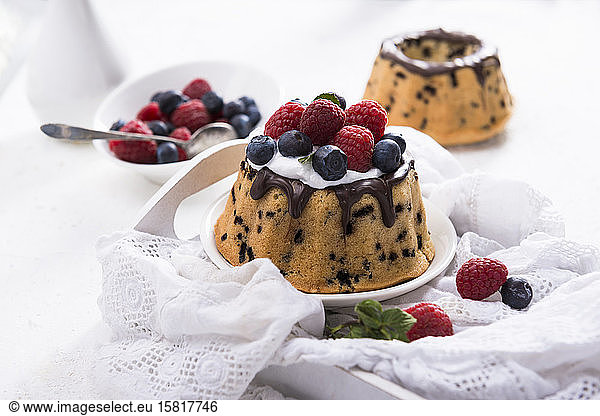 Small vegan stracciatella sponge cakes with soy cream and berries